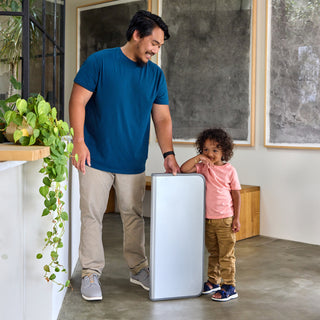 Homeowner installing the Backup Core power station with a young male child by his side.